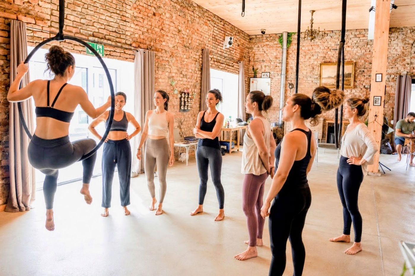 Sportgruppe beim Training im Fitnessraum des MAS MONTI mit Backsteinwänden und hohen Decken