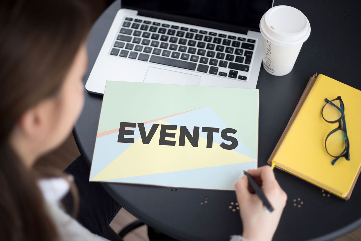 Notizbuch und Laptop mit dem Schriftzug Events