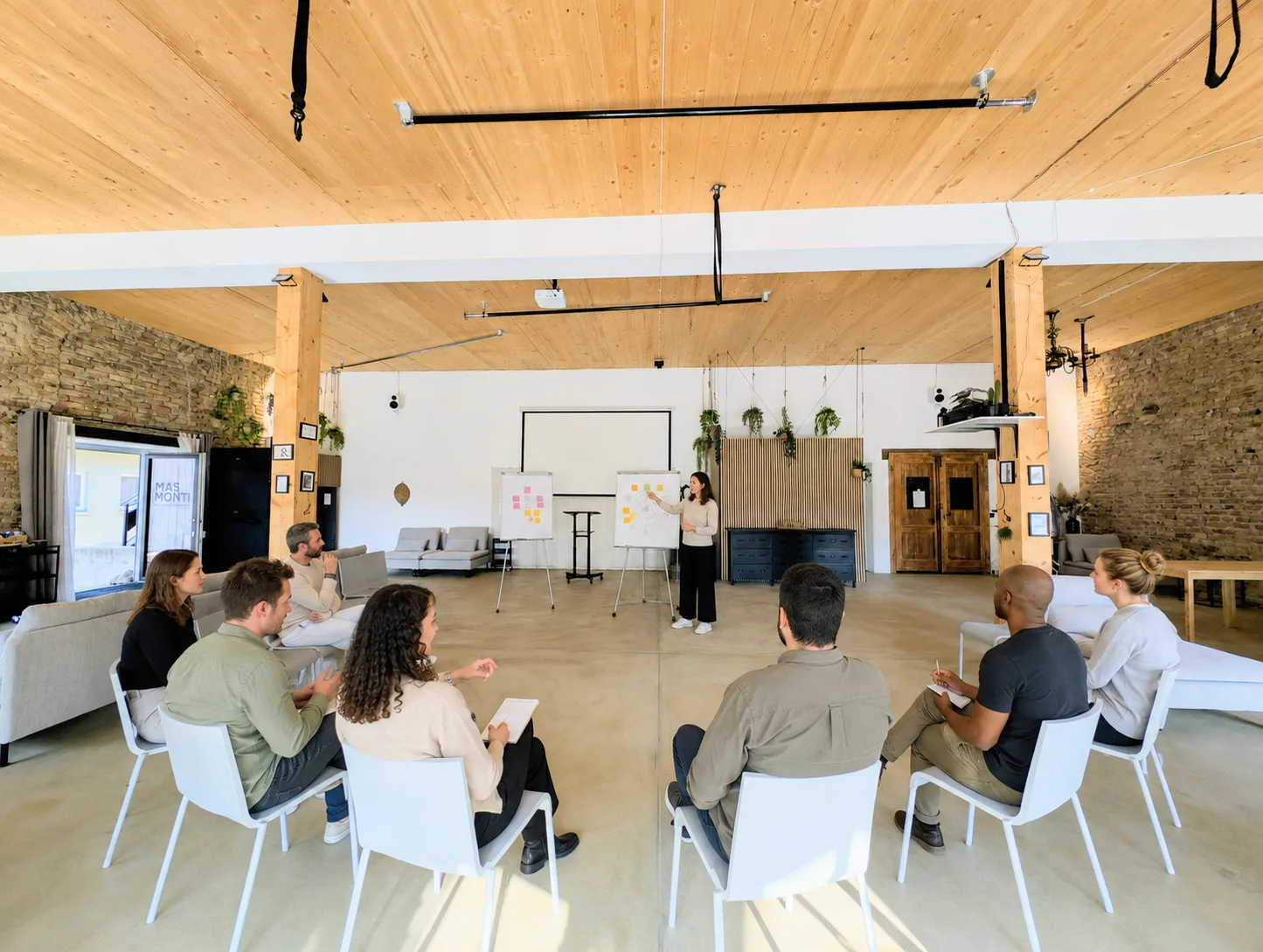Workshoprunde im MAS MONTI an Tischen vor der Backsteinwand